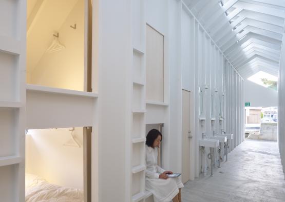 a woman sitting on a bench in a white room
