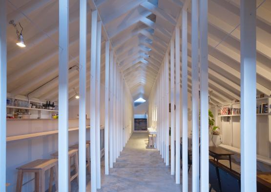 a long white room with wooden beams