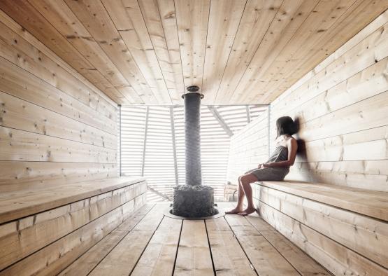 a woman sitting on a bench in a wooden room