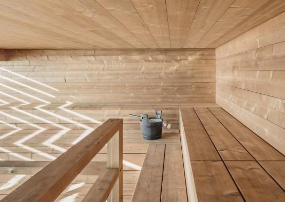 a wooden room with a bucket and a handrail