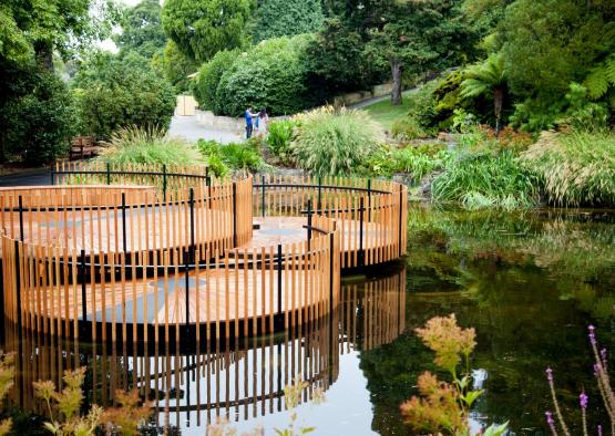a circular wooden walkway in a pond