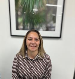 a woman smiling in front of a framed picture