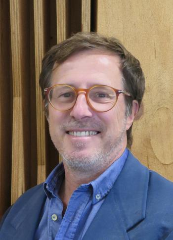 a man wearing glasses and smiling