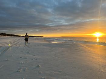 runner on the beach at sunset