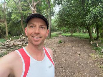 Runner Jon Shanks on trail surrounded by trees and nature
