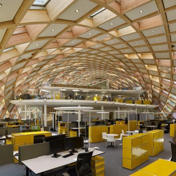 a large office building with many yellow tables and chairs