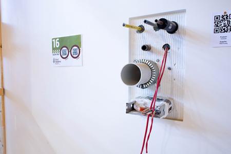 a white wall with pipes and wires