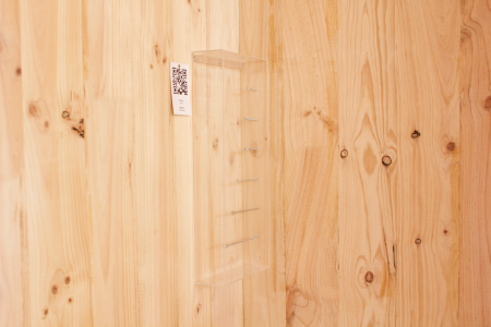 a clear plastic shelf on a wood wall