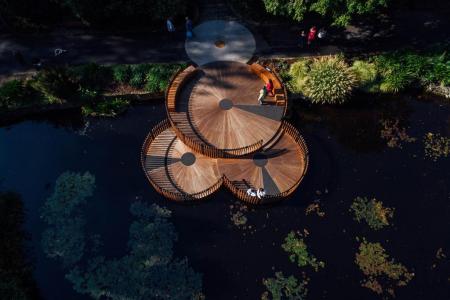 a wooden platform in a pond with people walking around