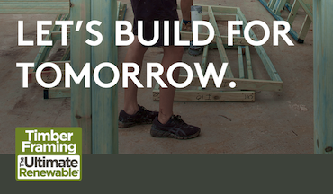 a man standing next to a wood frame