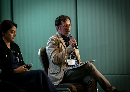 a man sitting in a chair holding a microphone
