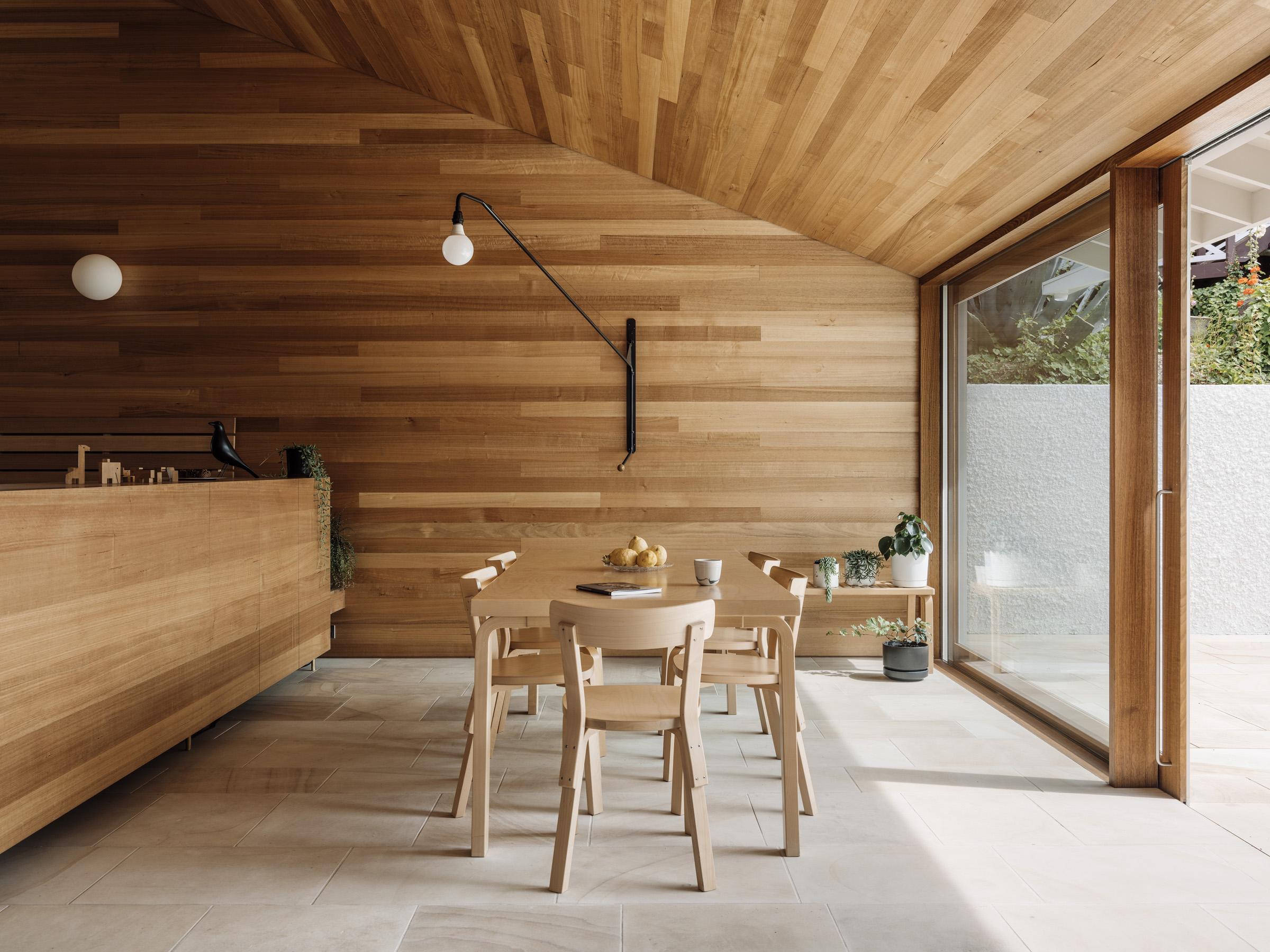 a dining table and chairs in a room with a glass wall