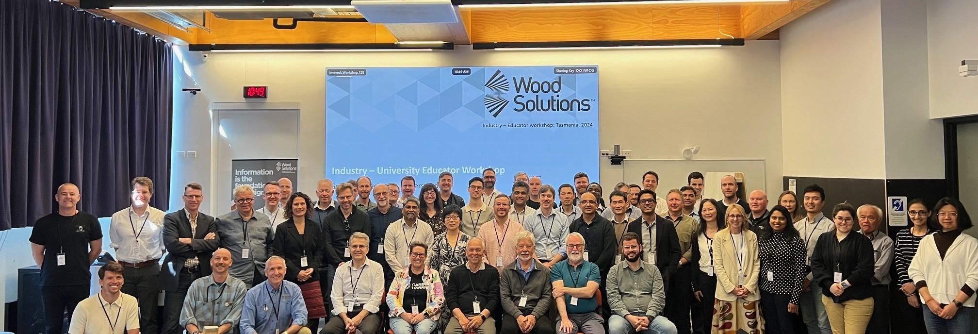 Large group of people standing together in front of presentation