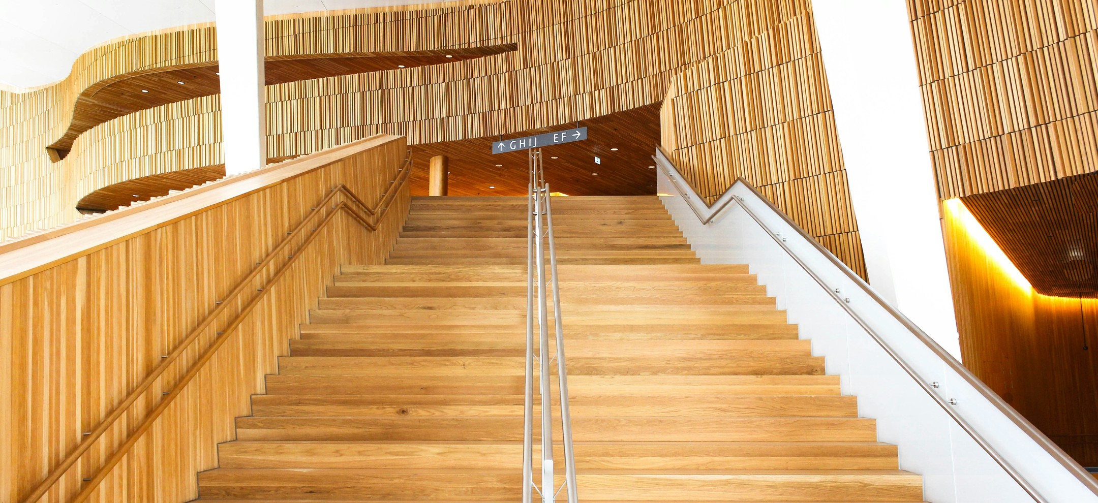 Looking up timber staircase with timber lining the walls above