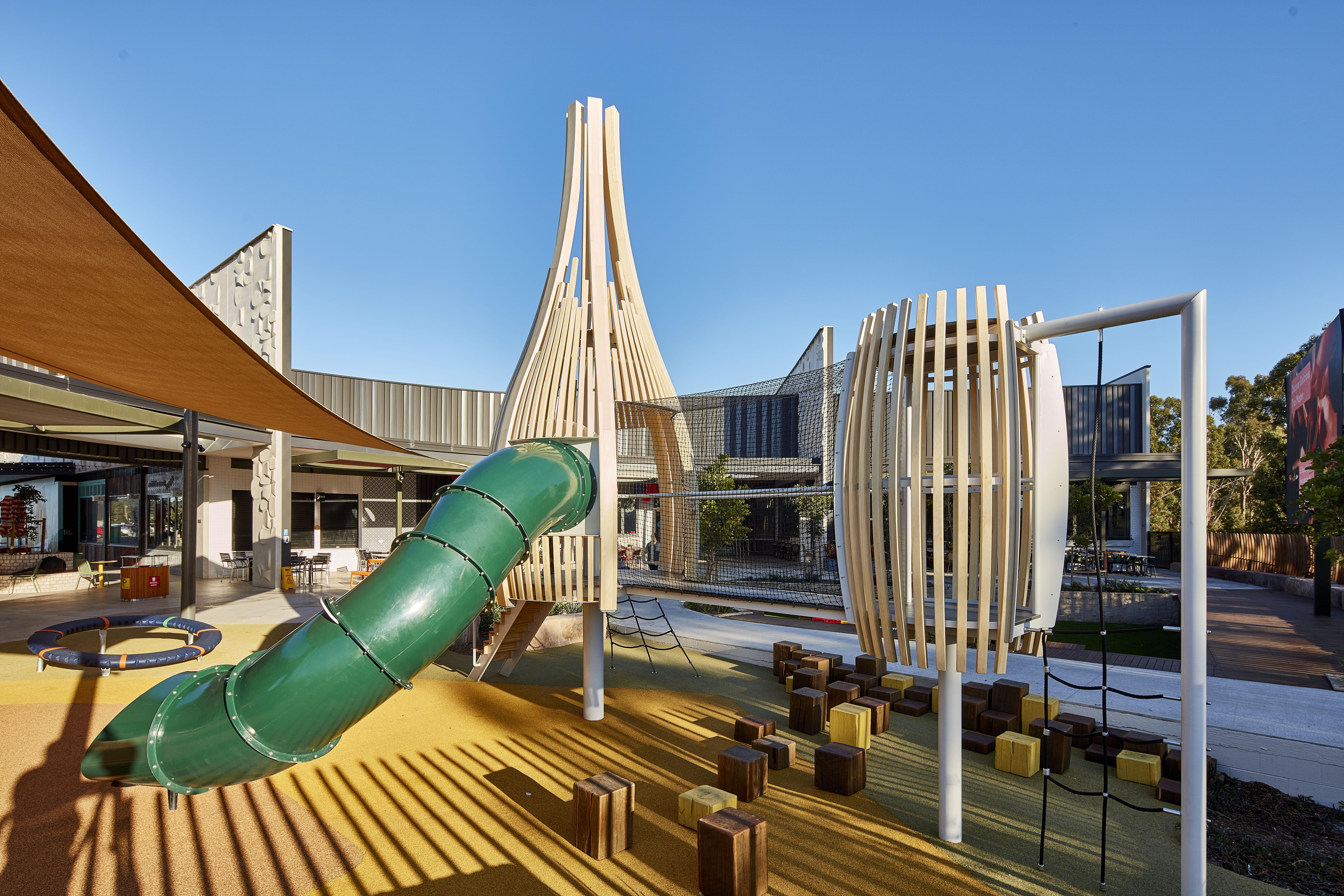 a playground with a slide and wooden structure