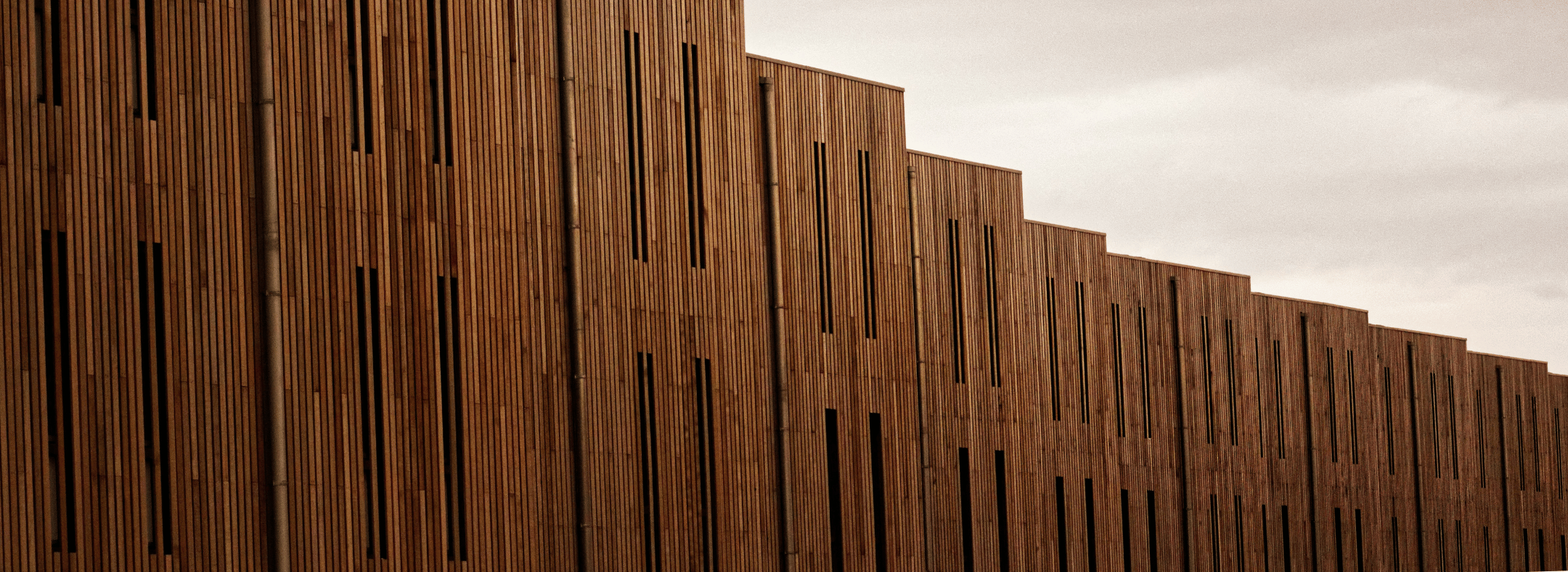 Timber clad building exterior against a moody grey sky