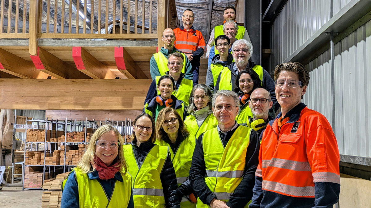 Group of people in high-vis posing on mass timber staircase