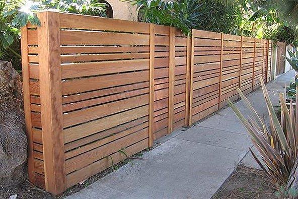 a wooden fence with a fence in the background