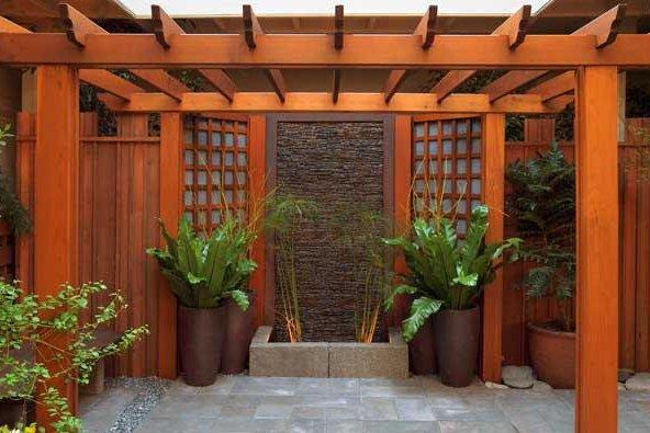 a wooden pergola with plants in pots