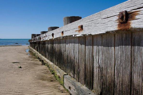 a wooden fence on a beach