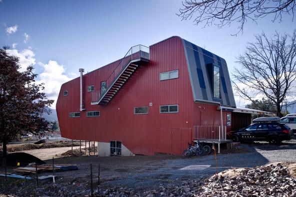 a red building with stairs and a car parked in front of it
