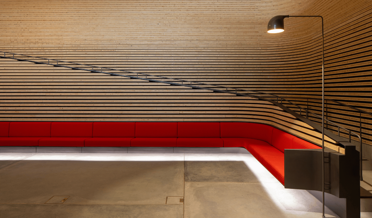 Timber clad walls surrounding a red seat. Phoenix Gallery. Photo by: Martin Mischkulnig