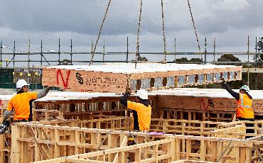 a man in a yellow jacket and white helmet working on a construction site