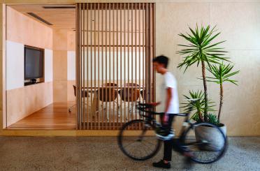 a man walking with a bicycle in a room