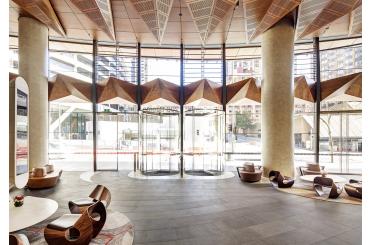 a lobby with a glass door and chairs