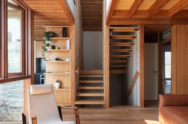 a room with wood stairs and a chair