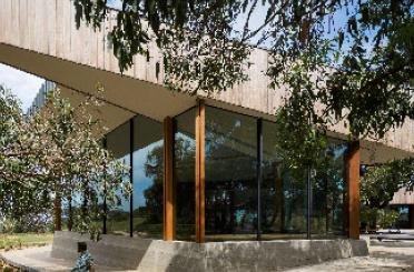 a building with glass walls and trees