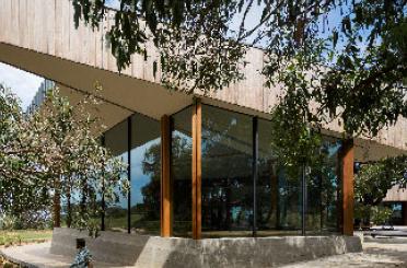 a building with glass walls and trees