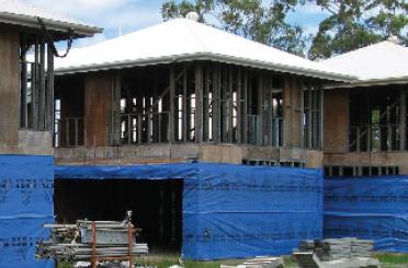 a building under construction with blue tarp
