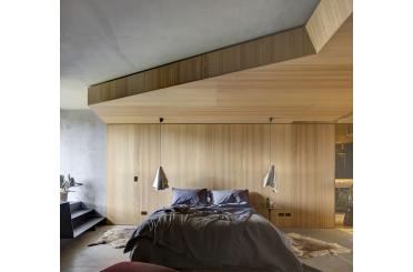 a bedroom with a bed and a wood wall