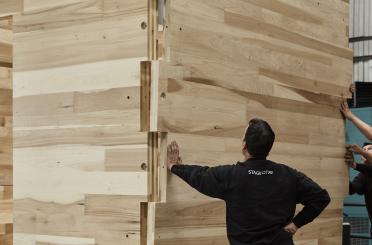 a man touching a wood wall