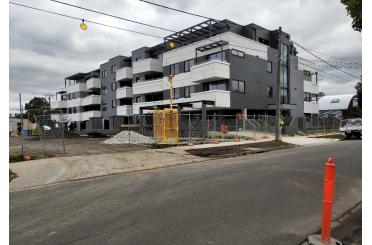 a building under construction with a road and power lines