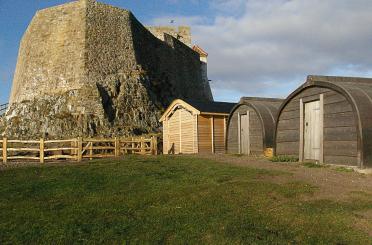 a stone structure with a large stone wall and a building