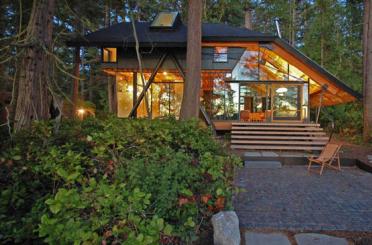 a house with a deck and a walkway in the woods