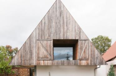 a triangular wooden building with a window