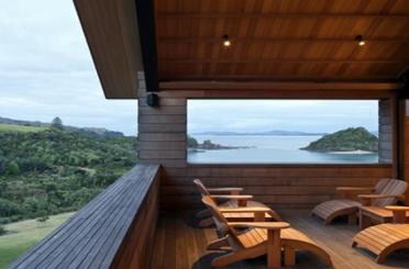 a deck with chairs and a view of the ocean