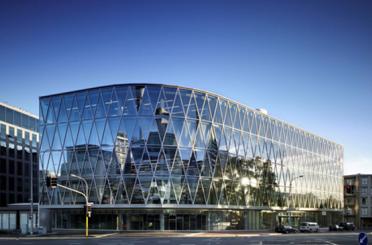 a glass building with a curved roof with Sprint Center in the background